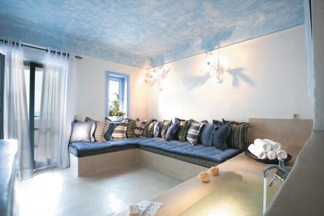 греческие интерьеры угловой диван-лежанка с бело-голубыми подушками и крашеный голубой потолок
