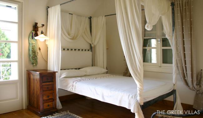 греческие интерьеры-спальня кровать с белым полупрозрачным балдахином