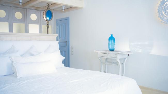 греческие интерьеры - бело-голубая спальня белая консоль с голубой стеклянной вазой-бутылью