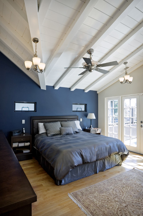 Цвет в интерьере - синие стены и покрывало в спальне со скатным потолком