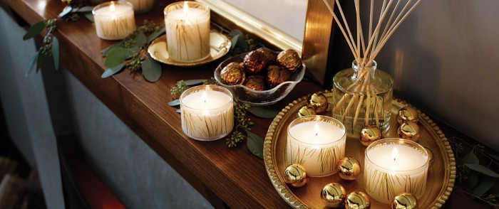 новогодняя декоративная композиция из свечей и золотых шаров на полке